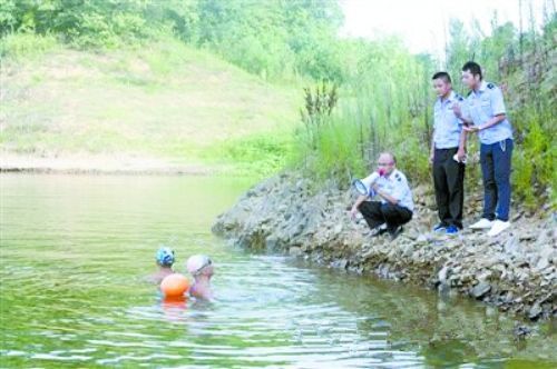 图为执法人员劝阻下水游泳者